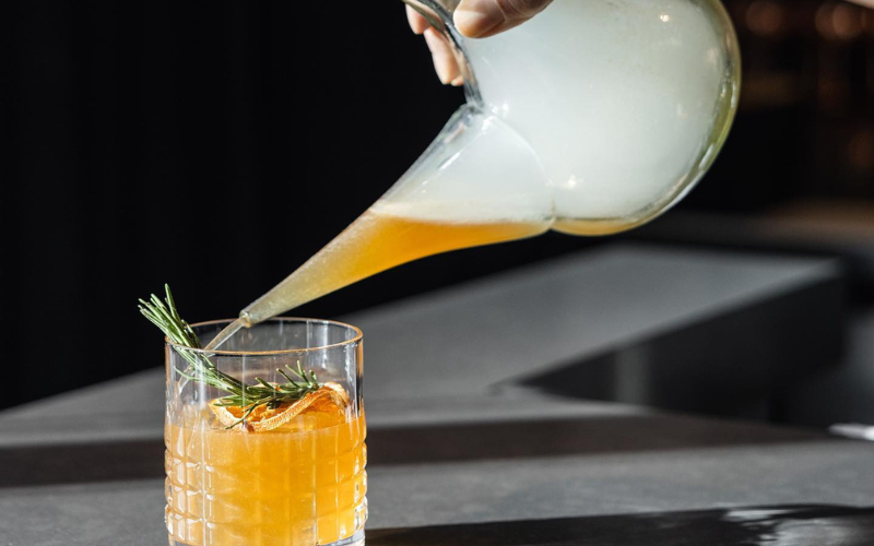 - DiningOut The Cocktails Experience a refreshing journey with the Walton Room's extraordinary cocktails. I tried the Oaxaca Vibes—an exceptional mezcal and Aperol cocktail brought to life by igniting dried lemon and fresh rosemary, then extinguishing it in smoke. The flavorful mix of oak, citrus, and herbs is the perfect way to whet your palate for your culinary journey.