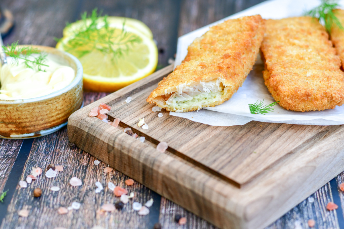 - DiningOut Fish and chips.Close up of crispy breaded deep fried alaska pollock fillets with breadcrumbs served with remoulade sauce french fries and lemons