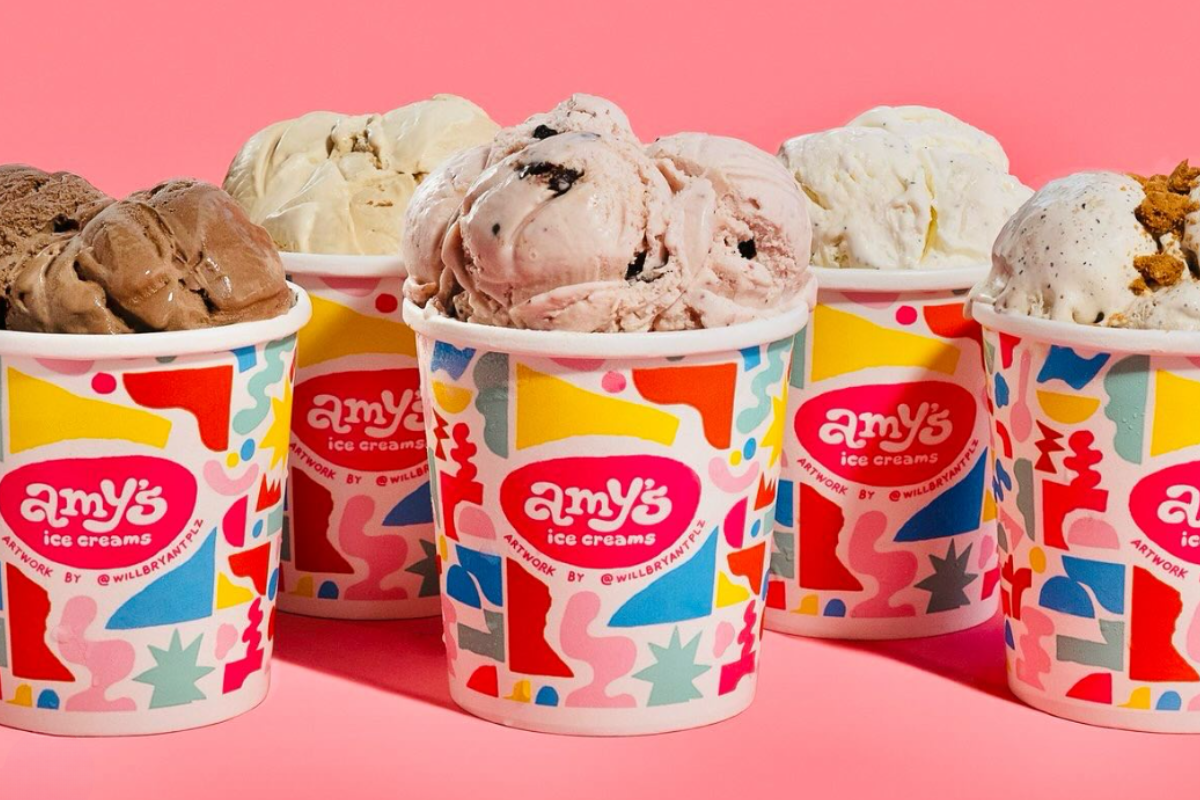 Colorful cups filled with creamy scoops of Amy's Ice Cream, featuring various flavors and toppings, set against a bright pink background.