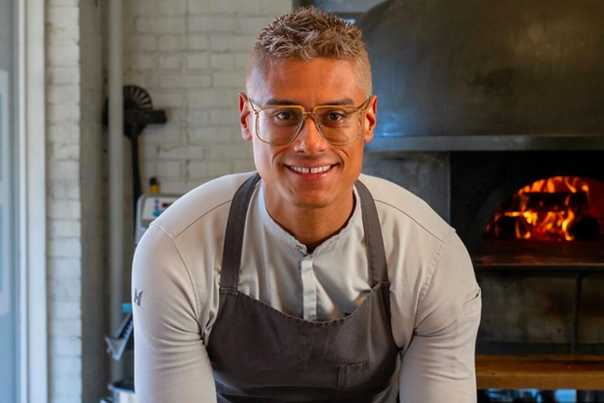 chef bryan gomez in front of fire and oven