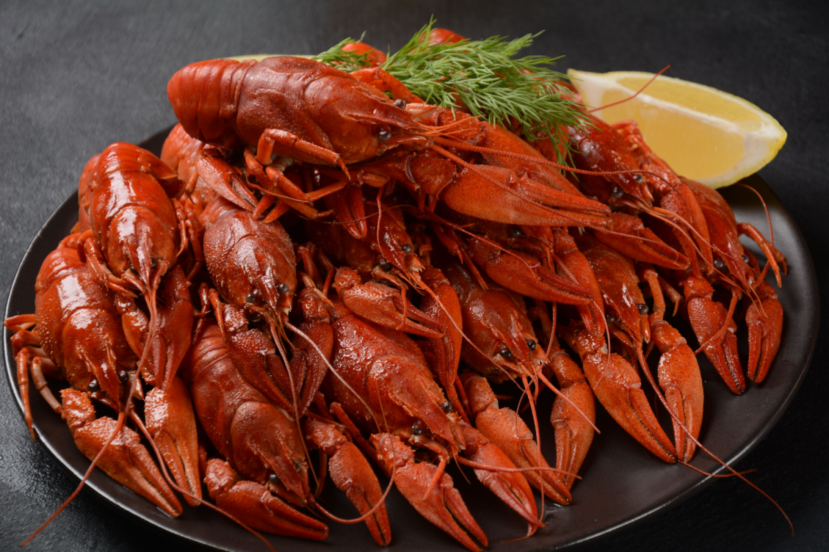 - DiningOut Red boiled crawfishes on table in rustic style.
