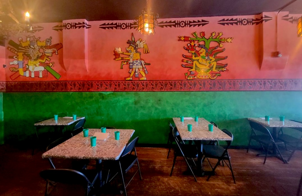 pink and green wall with tables in front news
