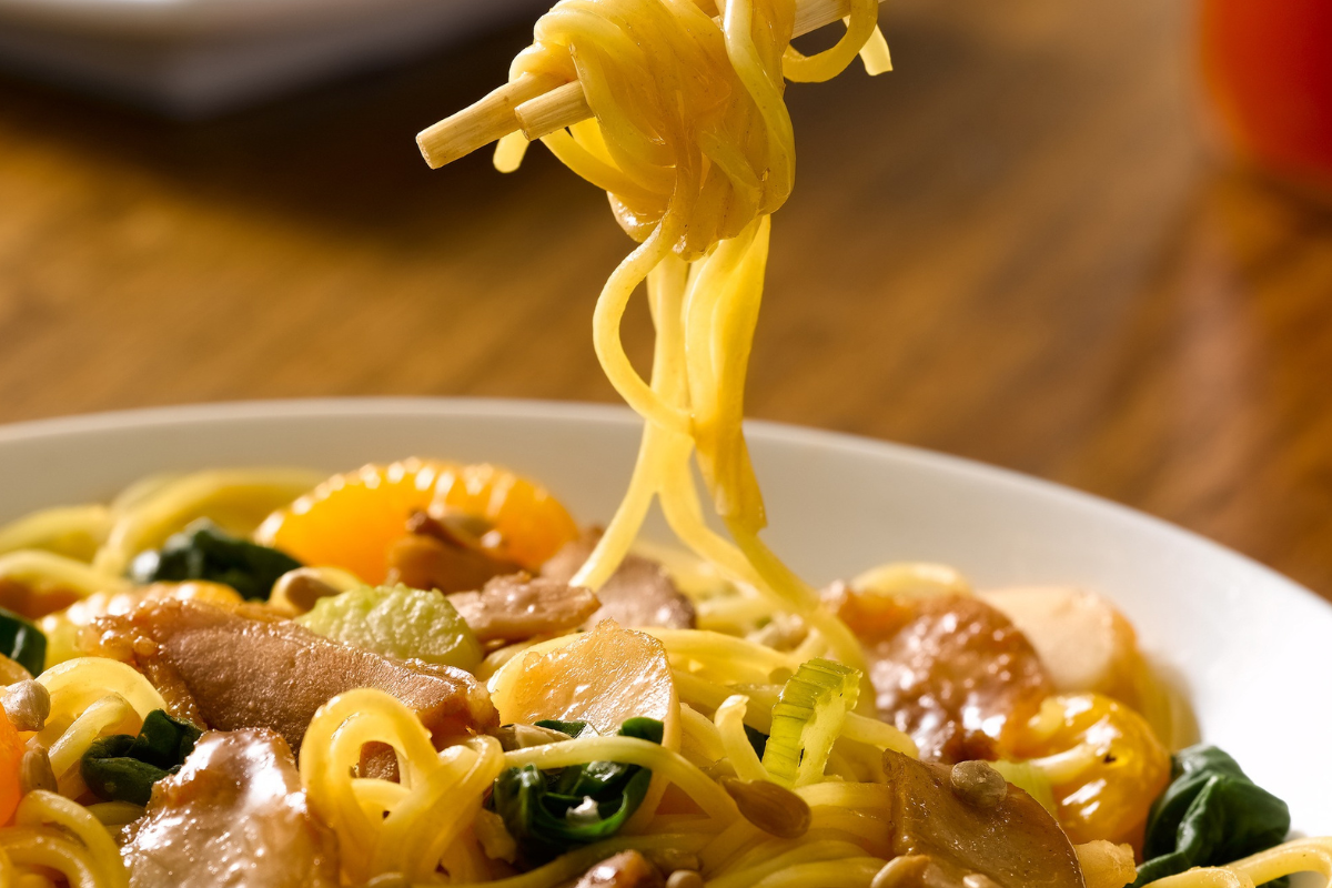 Stir-fried noodles with sliced meat, vegetables, and mandarin oranges at HuHot Mongolian Grill in Denver.

