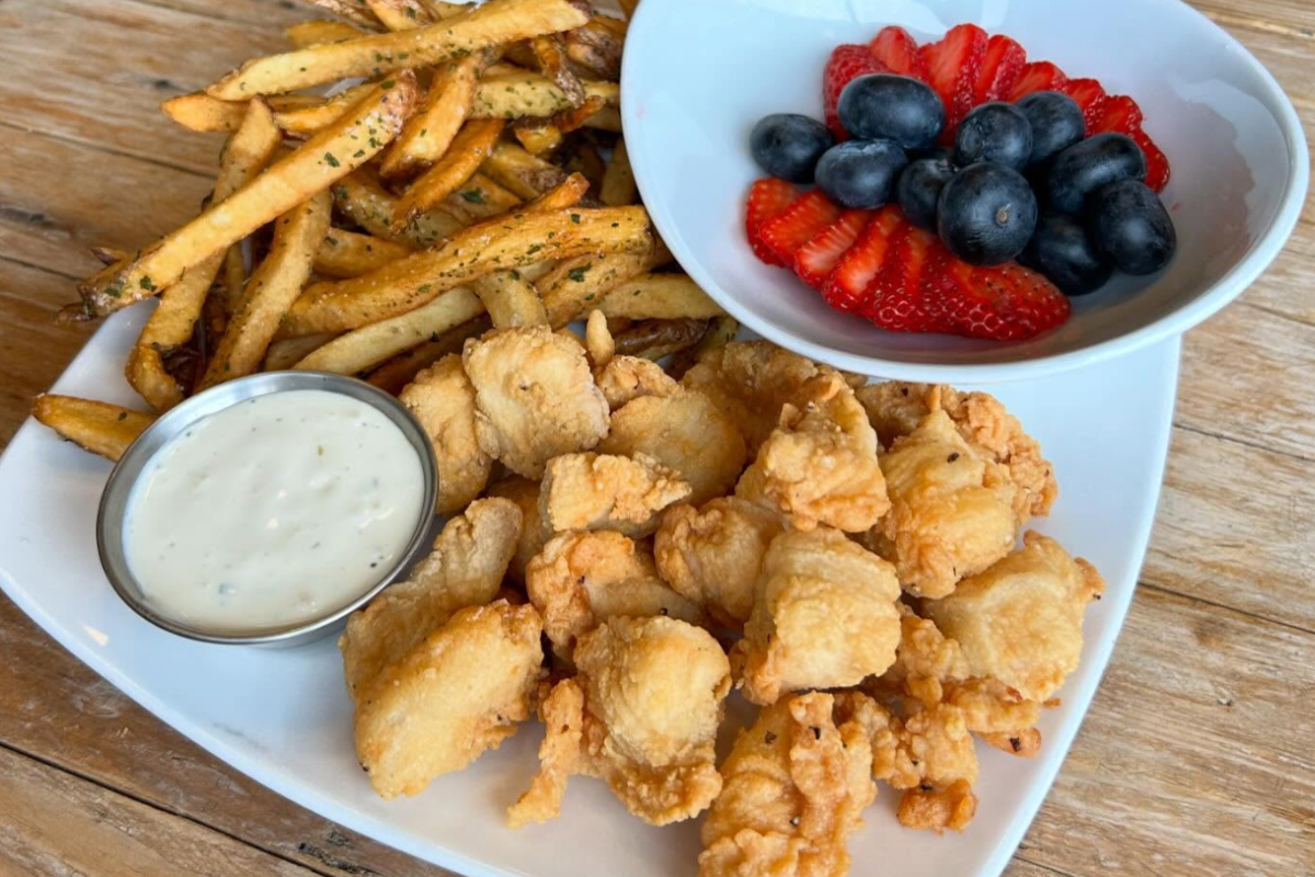 Plate of chicken bites with fries, ranch dipping sauce, and a side of fresh strawberries and blueberries at John’s Table in Louisville.