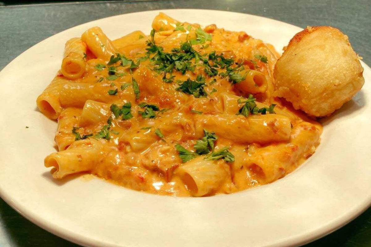 Rigatoni pasta in creamy tomato sauce topped with parsley and served with a garlic roll at Lil Ricci’s NY Pizza & Pasta in Denver.