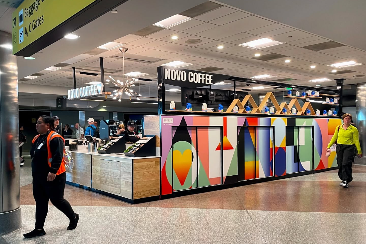 10 Must-Try Korean Restaurants in Dallas for BBQ, Tteokbokki & Fried Chicken Lovers - DiningOut Novo Coffee kiosk at the airport, featuring colorful wall art, modern lighting, and staff serving drinks to travelers walking by.