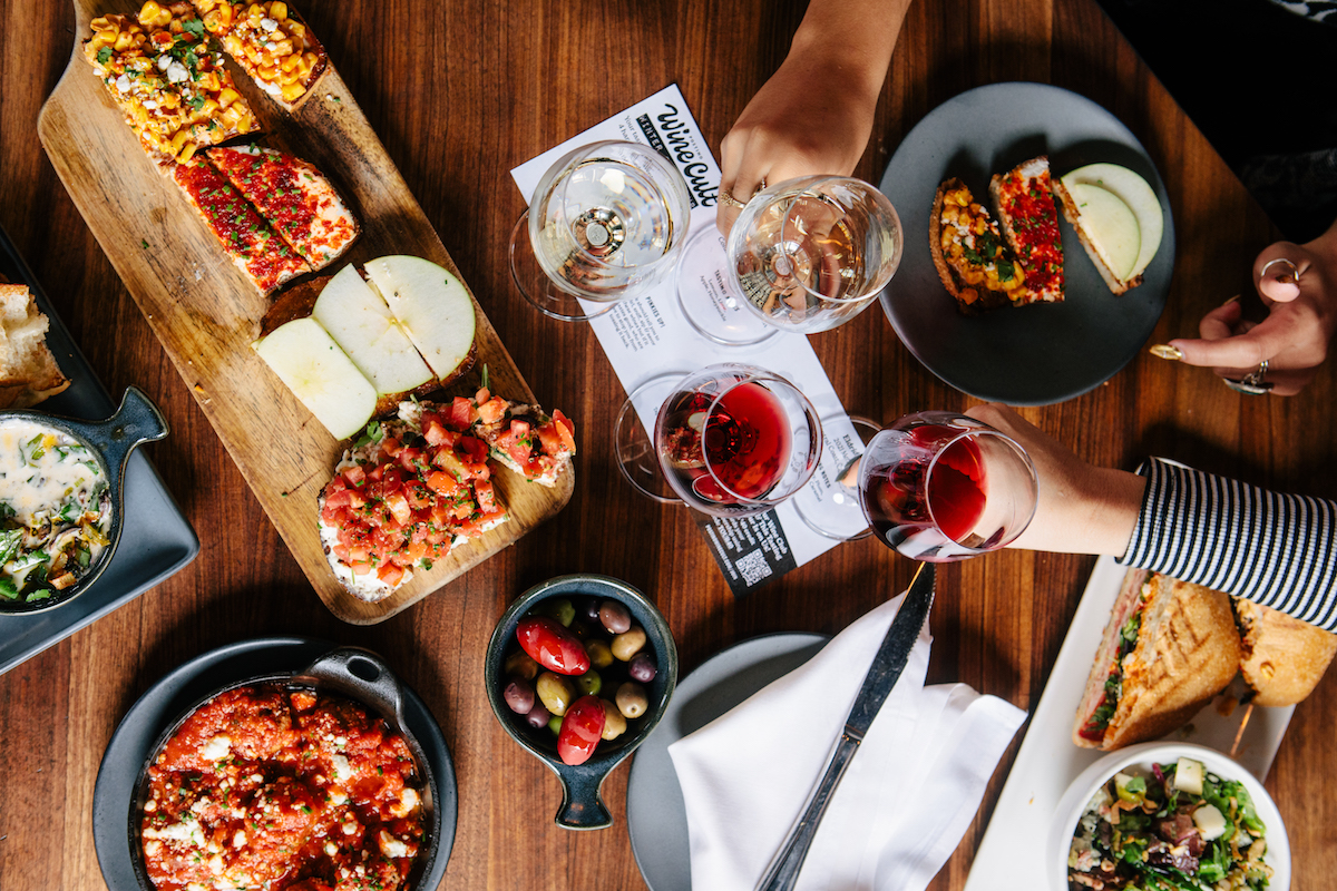 A wine toast over small bites and tapas at Postino WineCafe. | Photo by Postino WineCafe