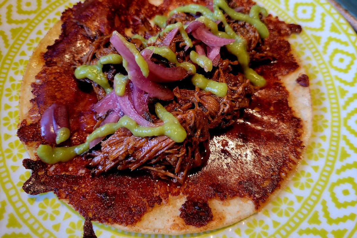 - DiningOut open taco with cheese and meat