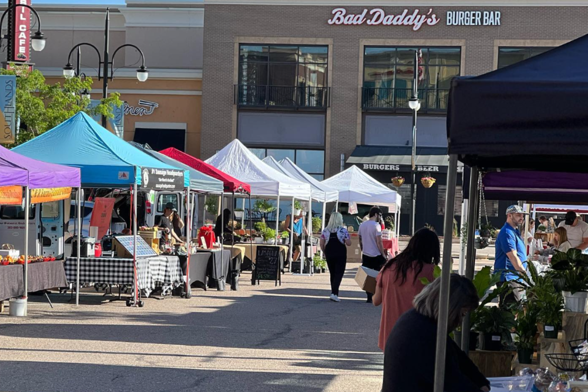 Southlands Farmers Market in Aurora, Colorado with vendor tents lined up along the street offering plants, produce, and local goods as shoppers begin to browse.
