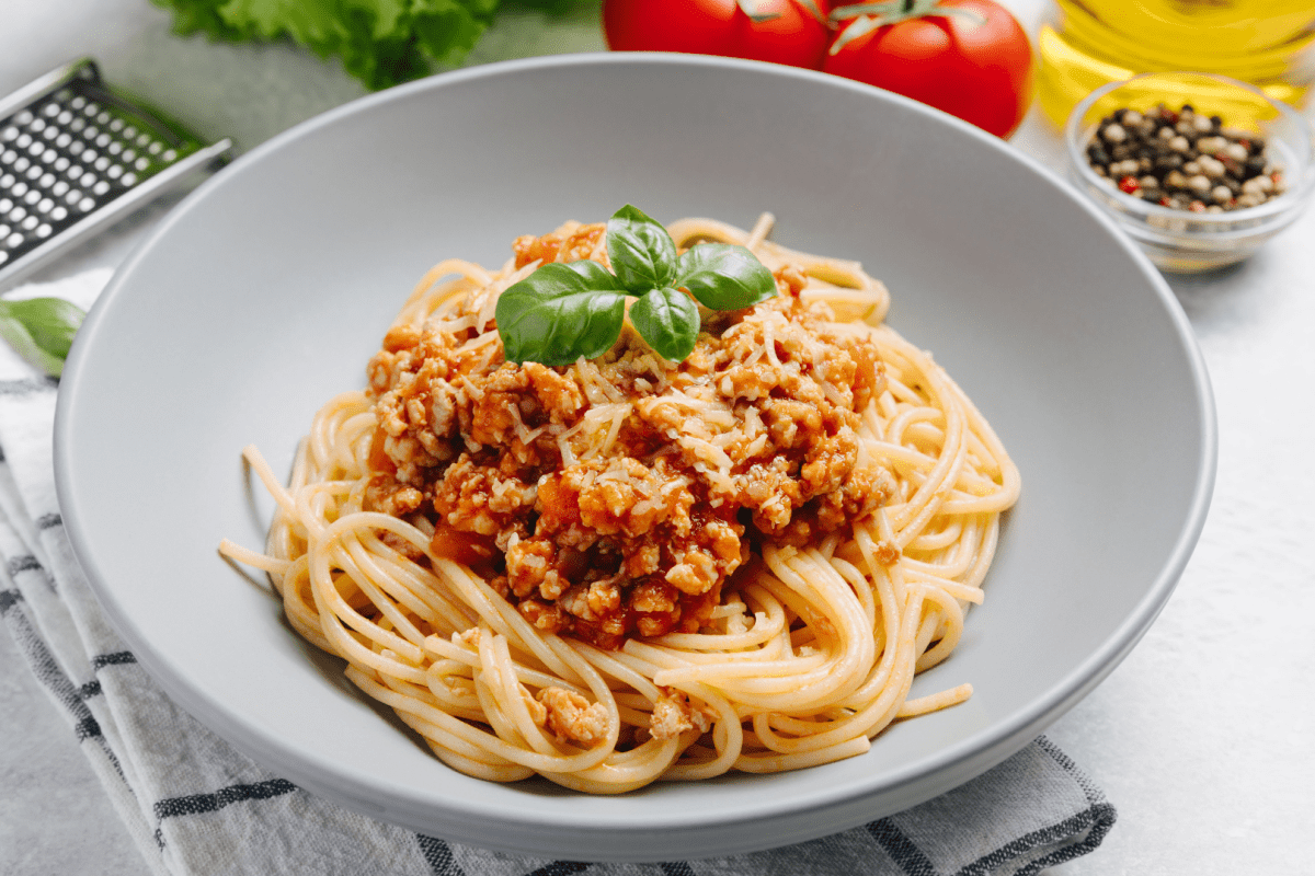 - DiningOut Traditional italian pasta spaghetti with bolognese meat sauce and parmesan on a light concrete, stone background. Close up