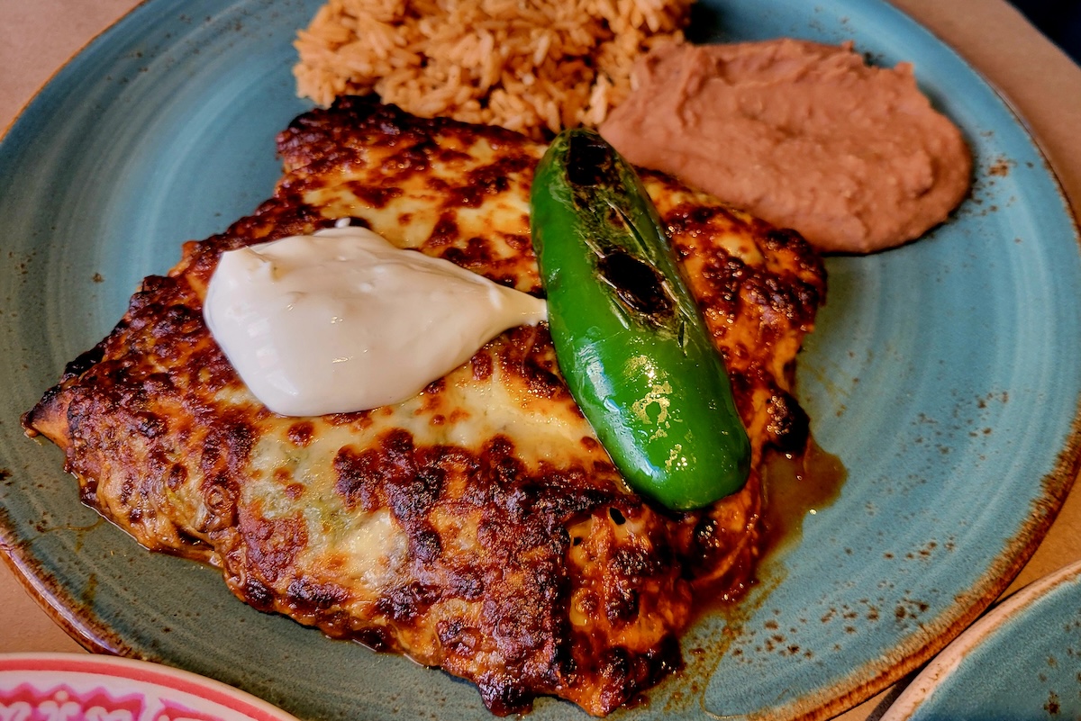 - DiningOut blue plate with enchiladas and a pepper