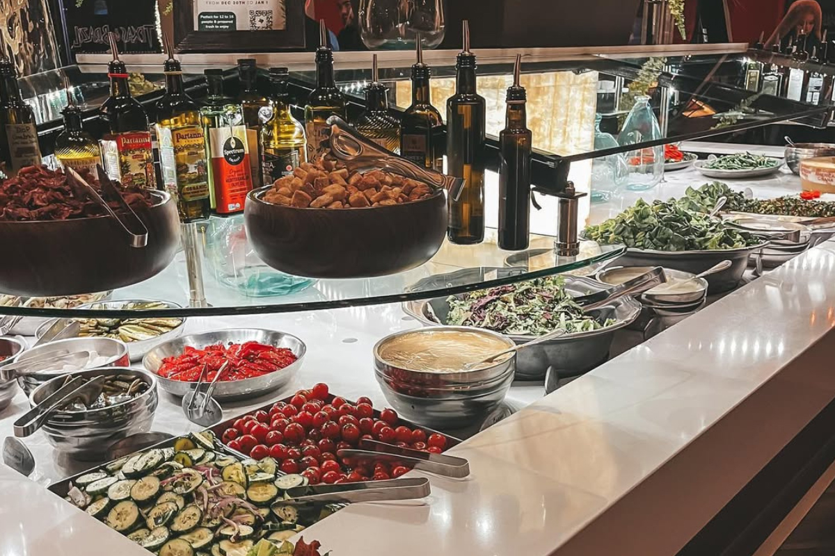 Salad bar with fresh vegetables, toppings, dressings, and oils at Texas de Brazil in Denver.