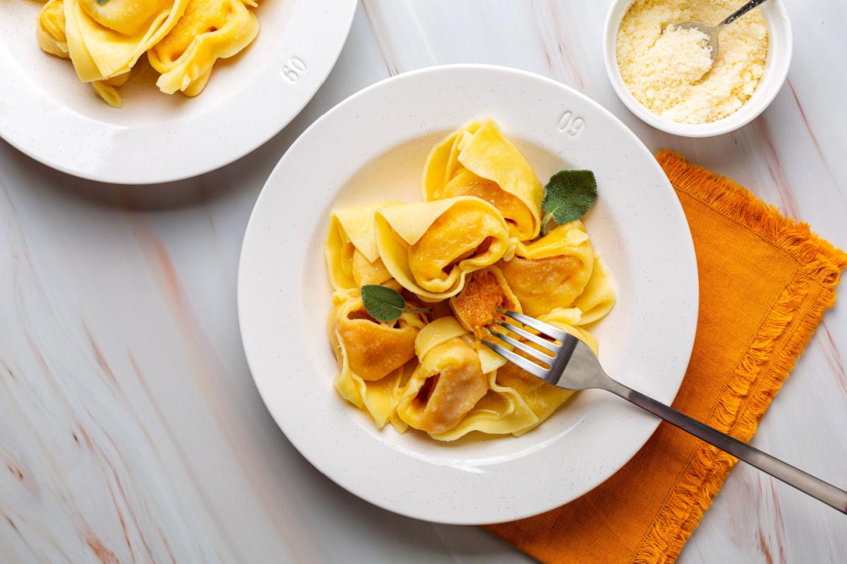 - DiningOut Tortelli or tortelloni di zucca, italian pasta pumpkin ravioli. Served with butter and sage, parmesan cheese. Top view.