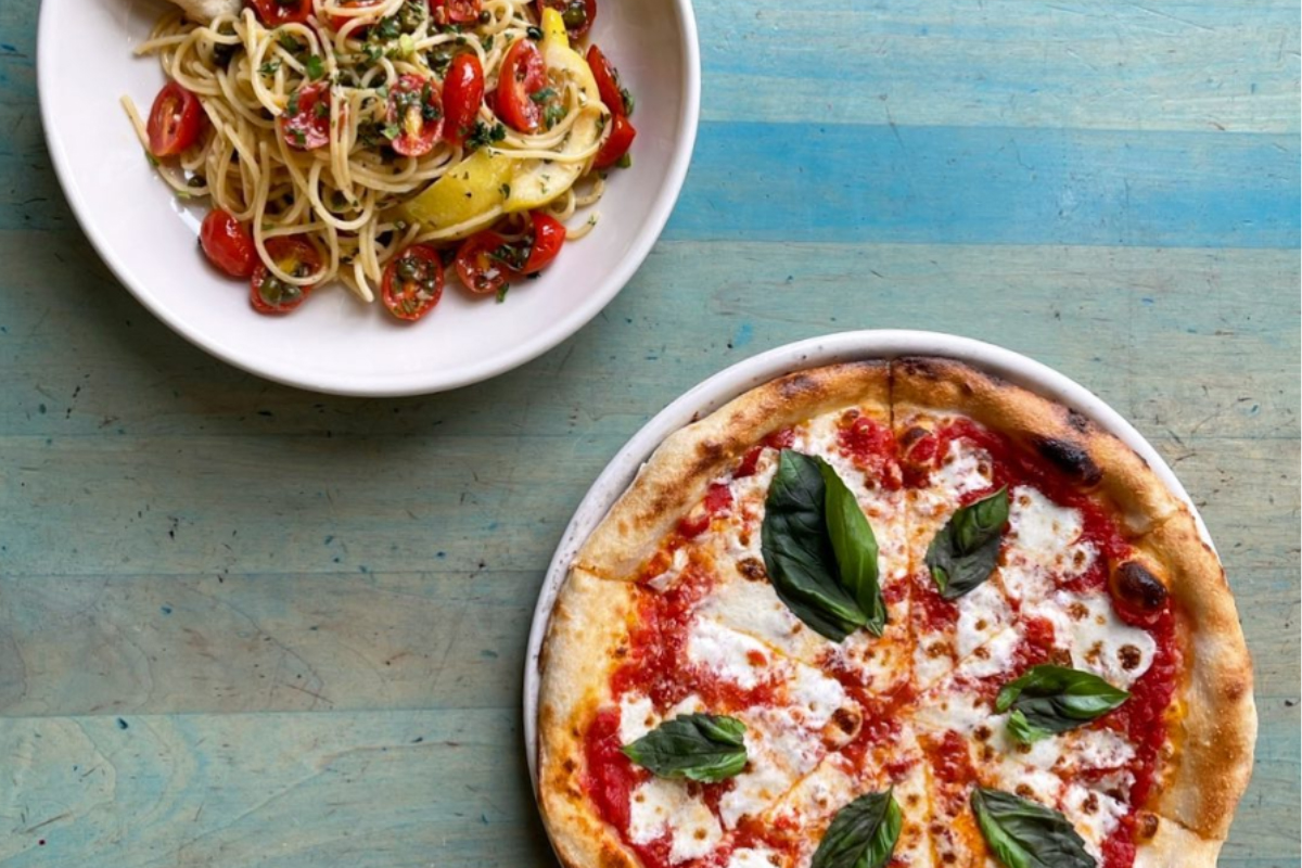 Margherita pizza and a plate of spaghetti with cherry tomatoes at Via Baci in Lone Tree.