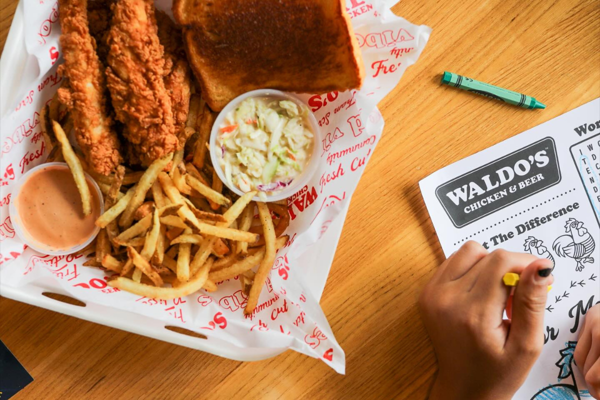 Chicken tenders with mac and cheese and dipping sauce at Waldo’s Chicken & Beer on a red tray.
