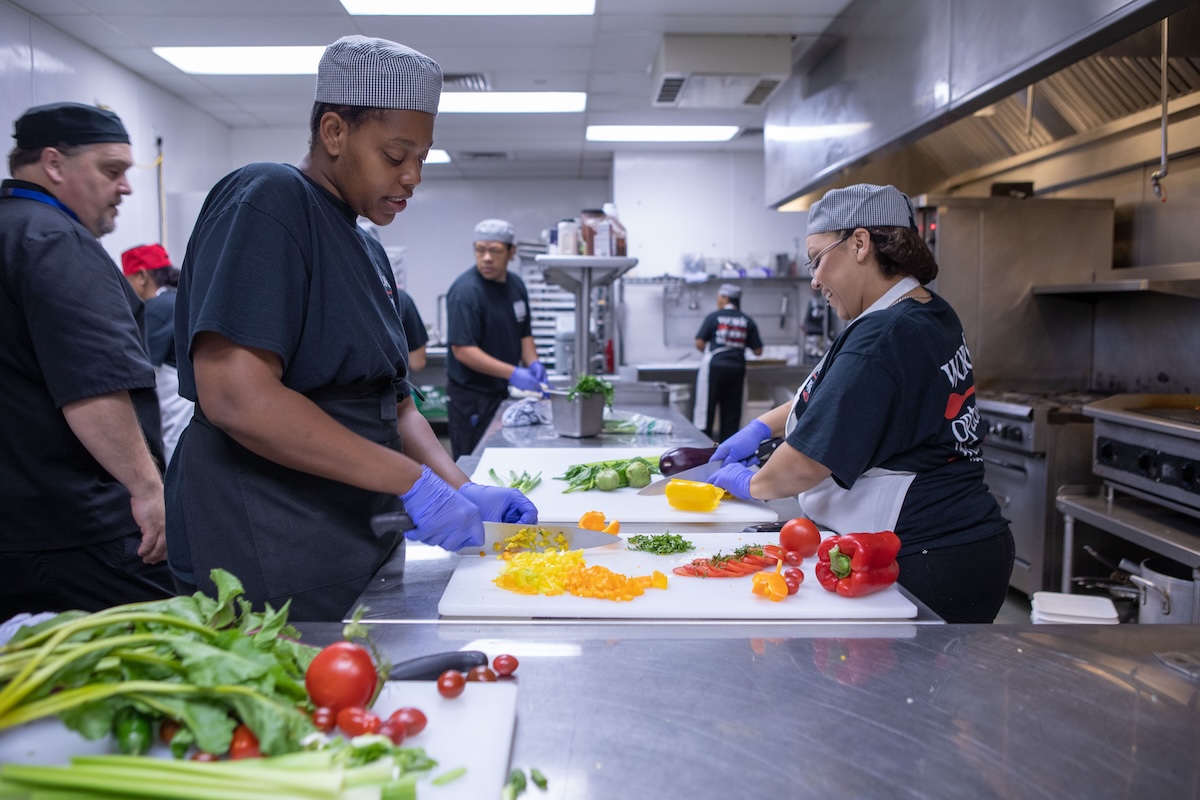 The teaching kitchen is busy all the time as students learn the proper way to prepare food. Photo by Work Options