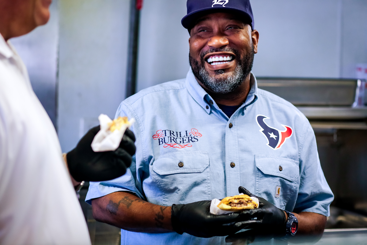 Bun B smiles while enjoying a Trill Burger at NRG Stadium. | Photo by Marco Torres