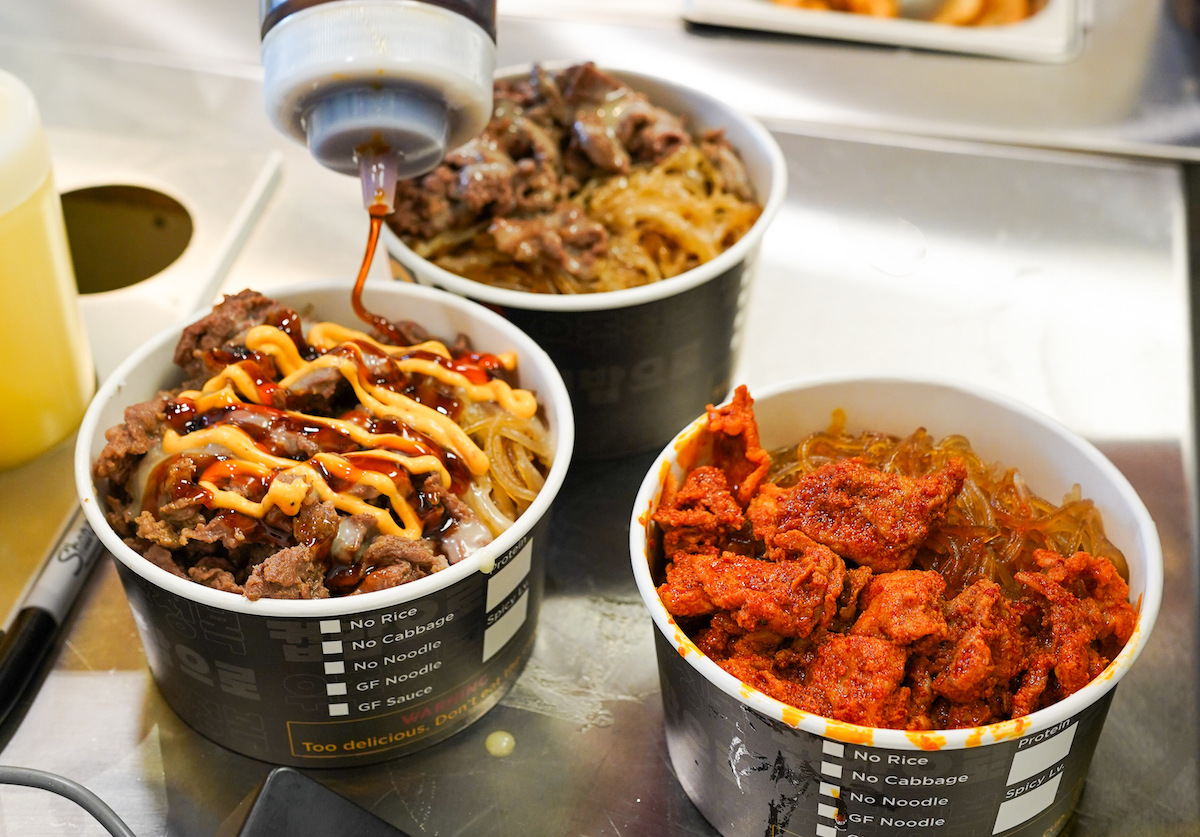 Bowls get a drizzle of sauce at Cupbop. | Photo by Cupbop