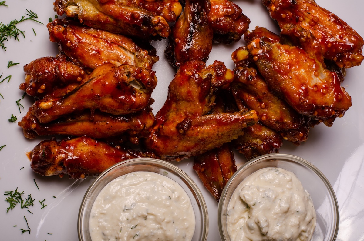 barbecue chicken wings close up on wooden tray shot with selective focus stock