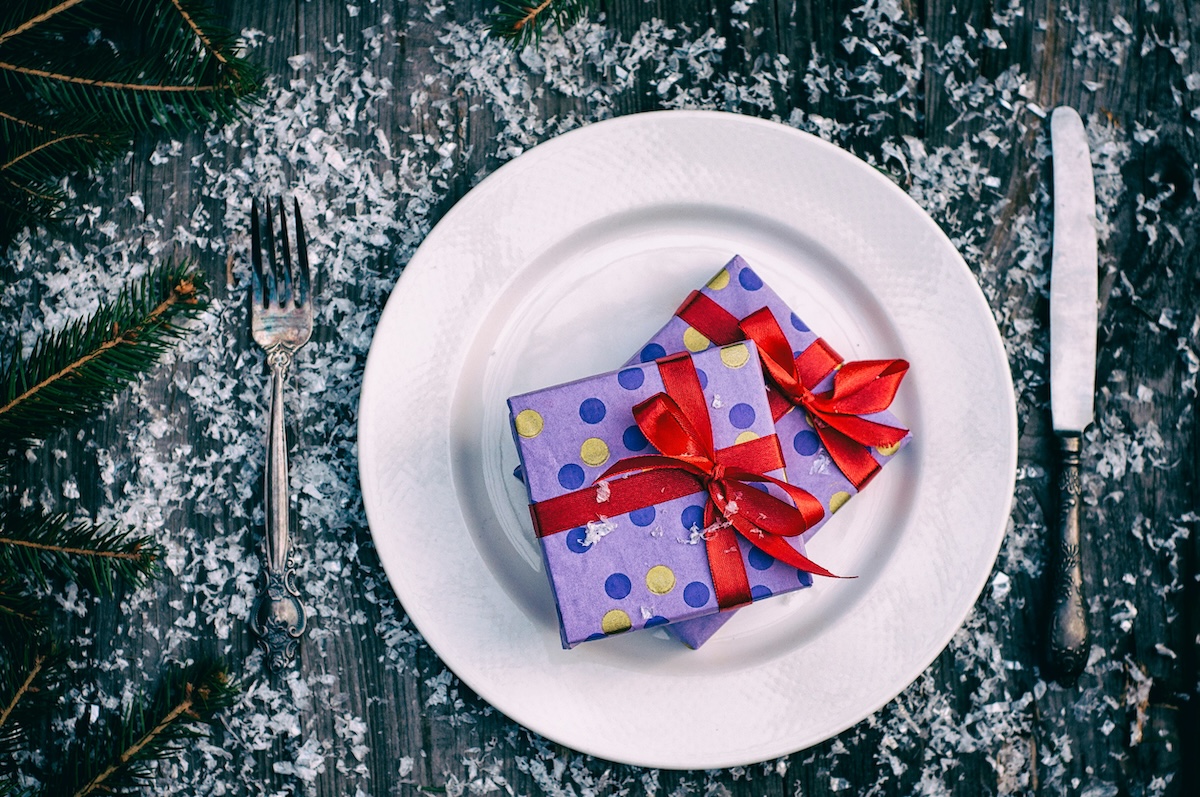 Christmas gifts on the white plate, gray wooden table with knife and fork, view from above, vintage toning stock photo ID: 69642354 by nndanko