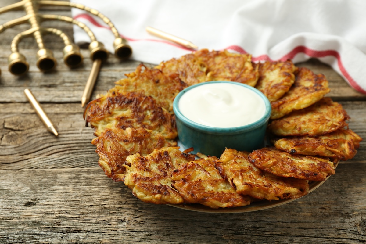 latkes stock image by liudmilachernetska ID: 244074384 Delicious potato pancakes, sour cream, menorah and candles on wooden table, closeup. Hanukkah festive food