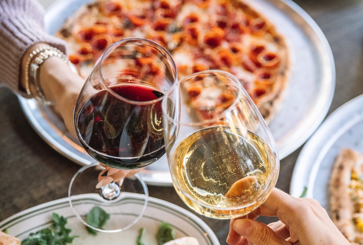 Wine toast over a pie at Delucca Gaucho Pizza & Wine. | Photo by Delucca Gaucho Pizza & Wine