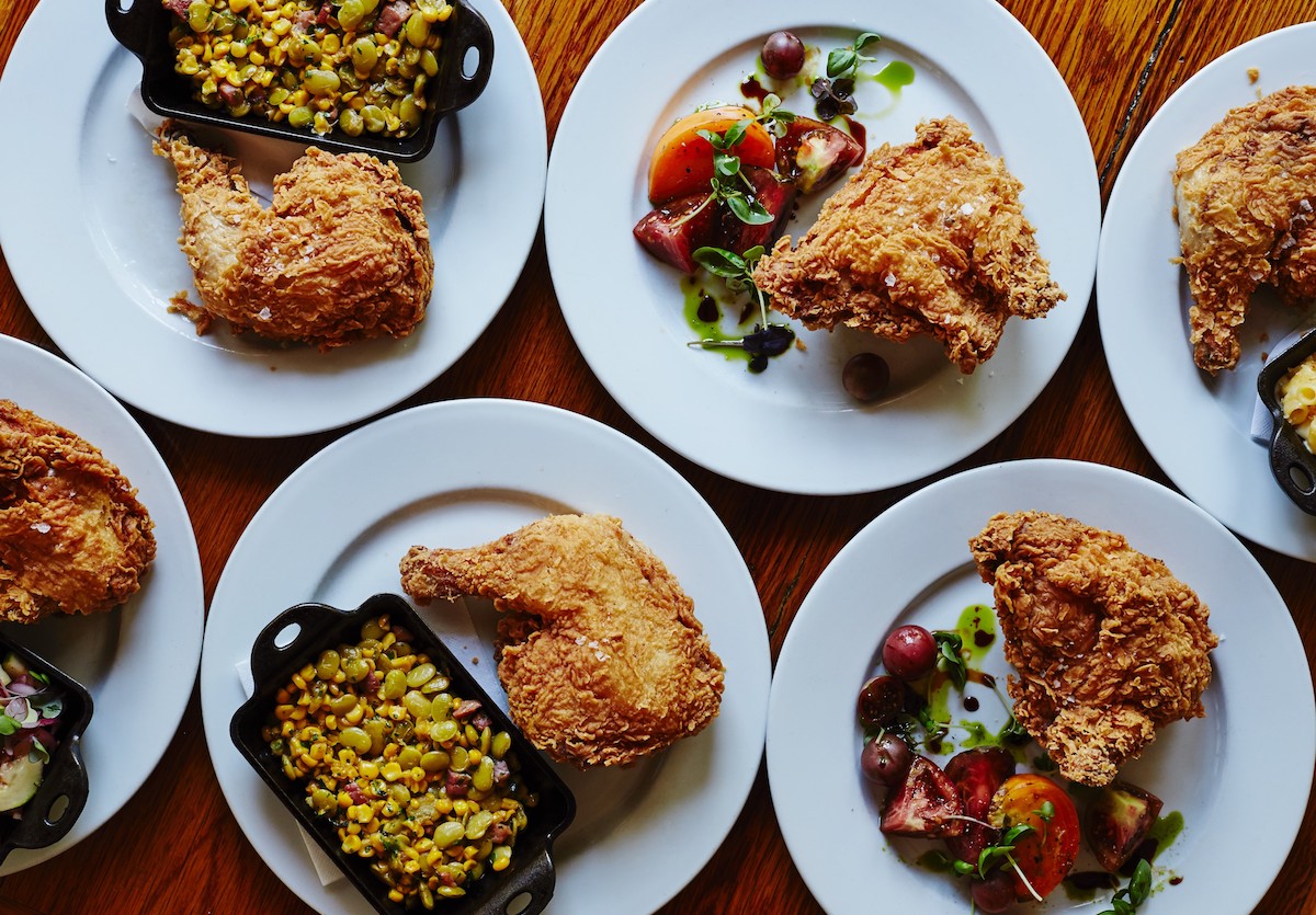 A mix of fried chicken legs and thighs with various sides at Table & Main. | Photo by Iain Bagwell
