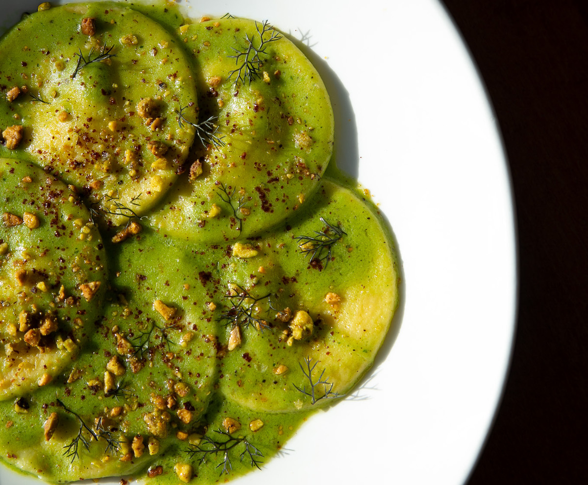Goat cheese ravioli with peas, mint, fennel, sumac, and pistachio at a mano. | Photo by Tomas Espinoza