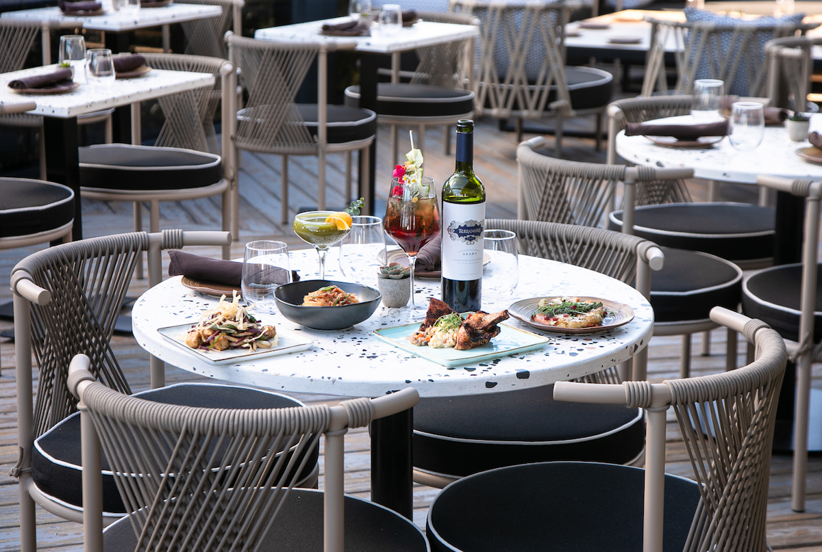A feast, complemented by a bottle of red, on the patio at Azara. | Photo by Erik Meadows Photography