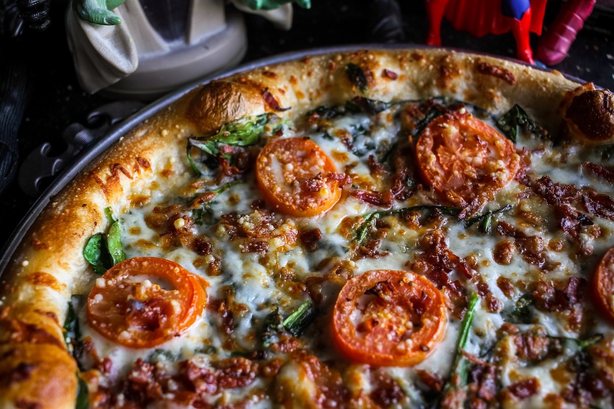 The signature bacon, spinach, and tomato pizza at Savage Pizza. | Photo by Savage Pizza