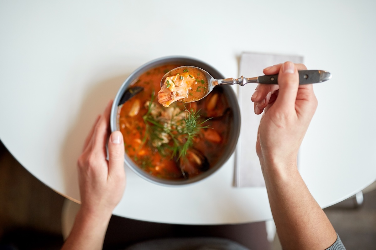food, new nordic cuisine and people concept - woman eating seafood soup with fish and blue mussels at cafe or restaurant Id: 70808666 by: D dolgachov