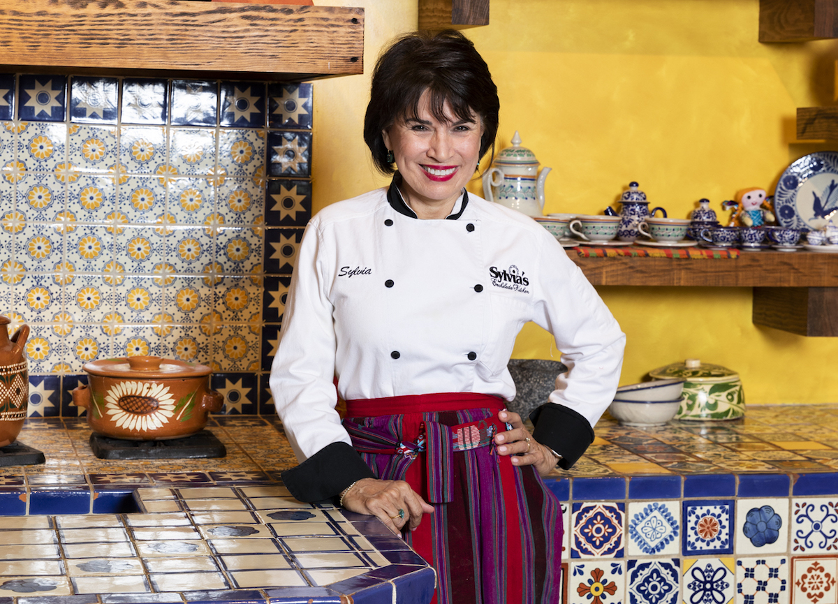 Sylvia Casares poses in the hand-tiled Puebla-style kitchen at Sylvia's Enchilada Kitchen. | Photo by Sylvia's Enchilada Kitchen