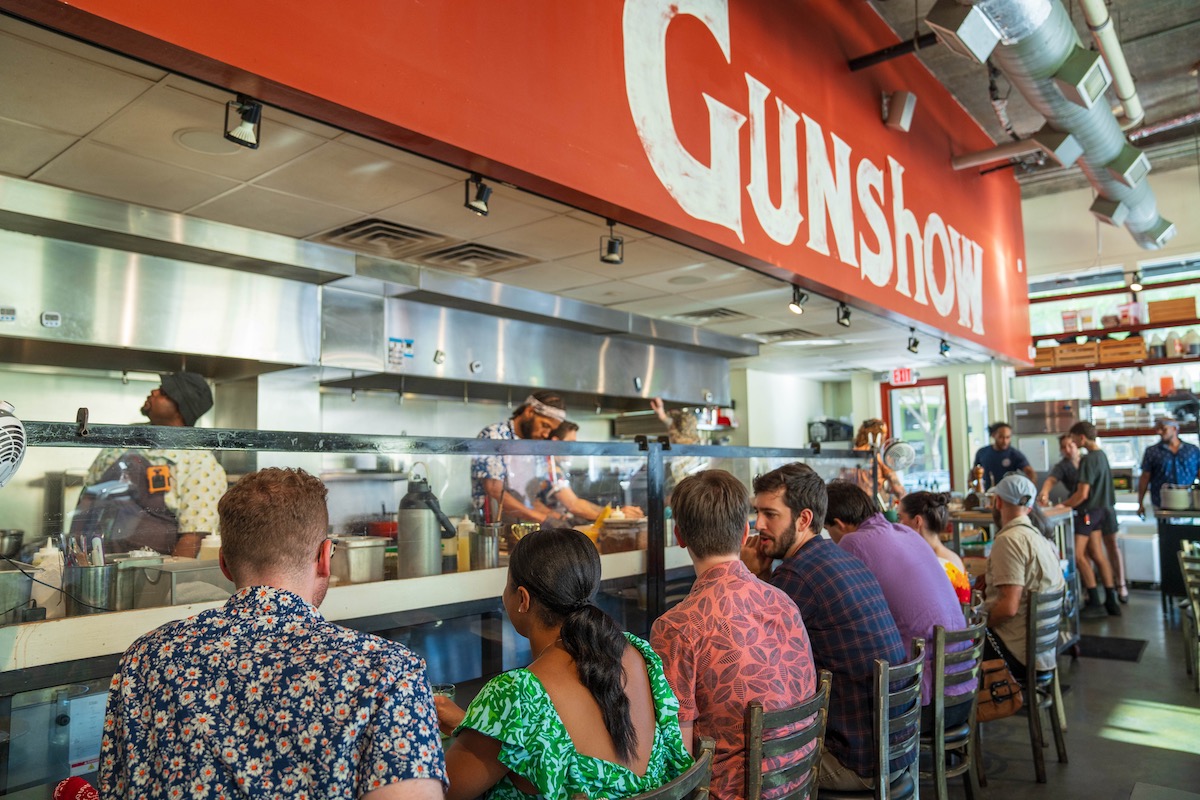Diners cozy up to the counter at Gunshow. | Photo by Blake Studwell