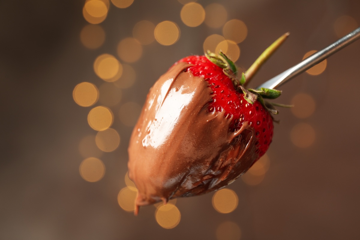 Chocolate fondue. Strawberry in chocolate against brown background with blurred lights ID: 148321329 BY: atlasfoto
