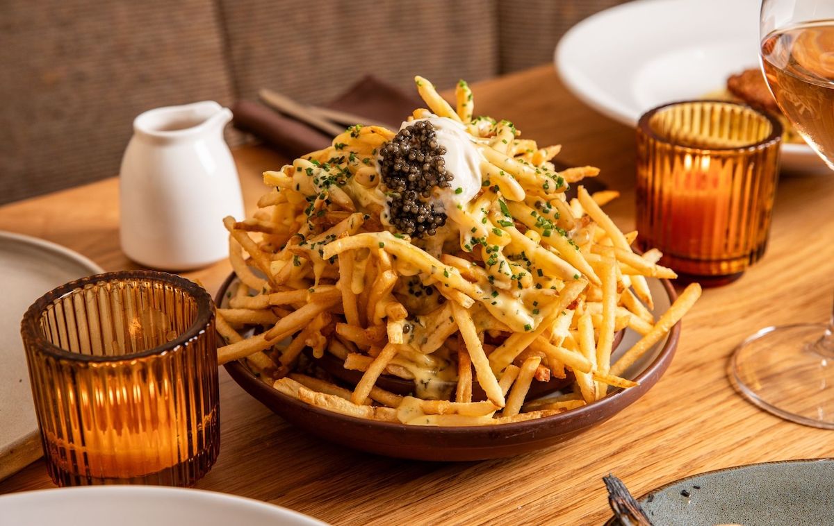 Caviar-topped fries garnished with crème fraîche and chives at Carmel. | Photo by Carmel