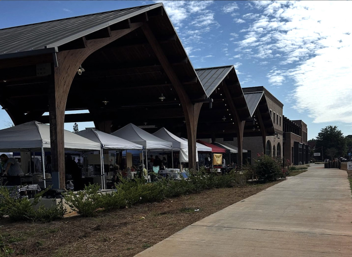 image6 - DiningOut Farmers market vendors in white tents gather under large wooden awnings at Avondale Estates Farmers Market. | Photo by Avondale Estates Farmers Market