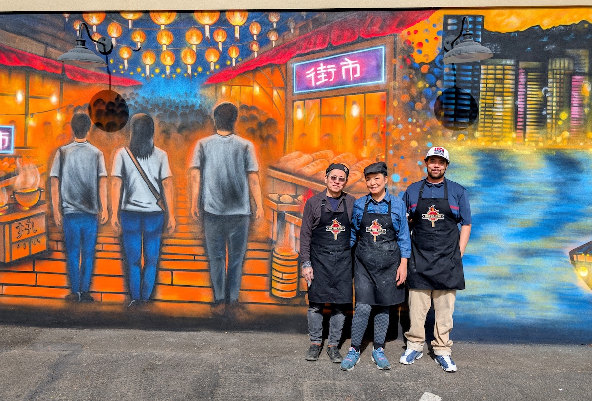 Ricky and Anna Choi in front of their night market mural at RedLine Station. | Photo by Linnea Covington 