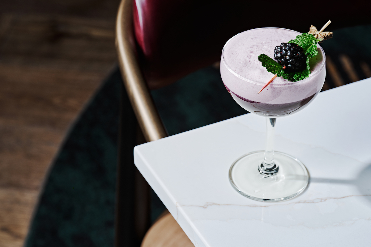 The non-alcoholic Butterflies on the Rail mocktail at Zephyr Southern Brasserie, made with butterfly pea, lemon, blackberries, and egg white foam. | Photo by Zephyr Southern Brasserie