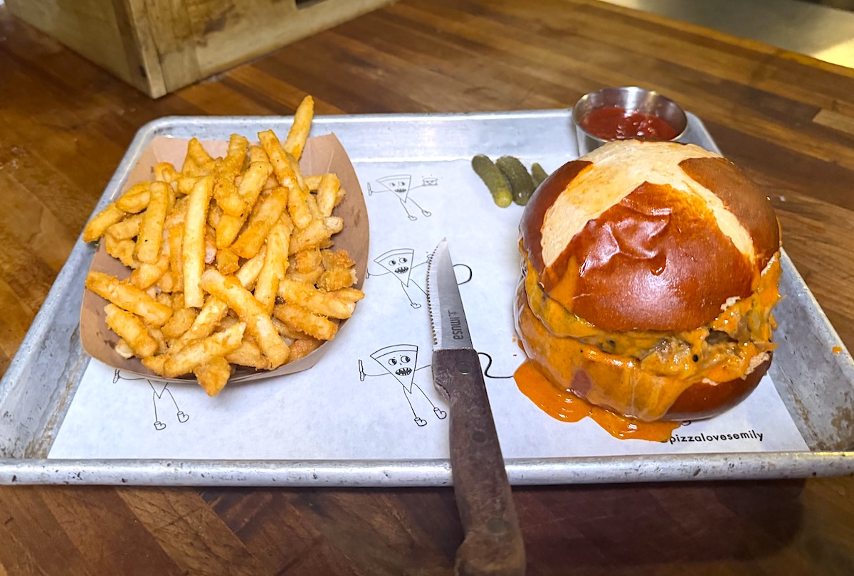 This beloved NYC spot might specialize in pizza, but the burger is just as nice. | Photo courtesy of Emily Brooklyn