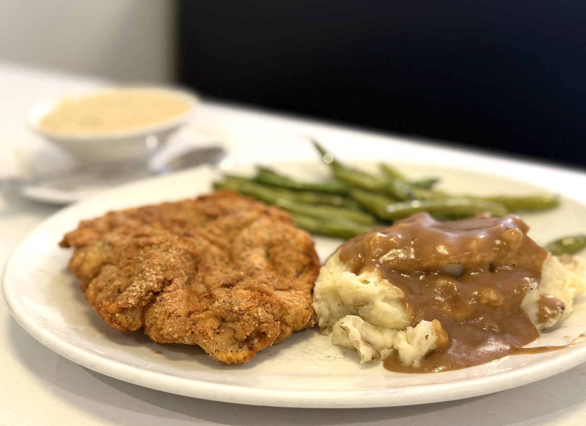 Golden chicken fried steak with mashed potatoes in rich brown gravy and a side of tender green beans—classic comfort done right at Luckys. | Photo by Steven Lindsey