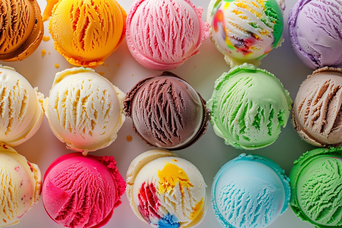 Assorted ice cream scoops of different colors and flavors on a white background