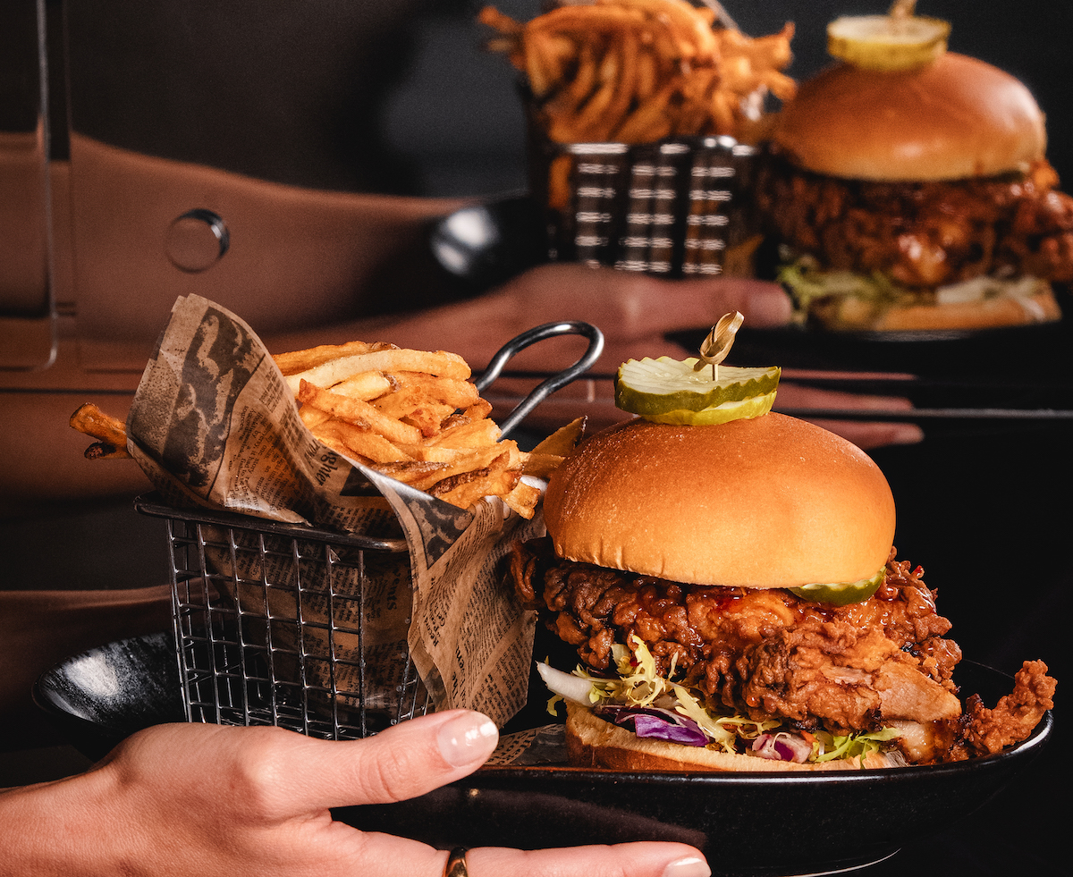 Crispy, spicy, and stacked sky-high, Bar Margot’s hot chicken sandwich is one of Atlanta’s standout takes on Nashville-style heat. | Photo by Sonder Media