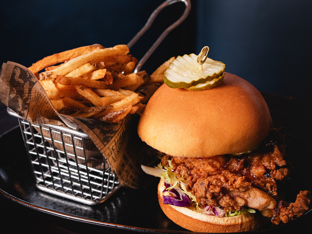 Bar Margot’s crispy chicken sandwich pairs sweet-hot honey, pickles, and golden fried chicken for an elevated take on Nashville hot chicken. | Photo by Sonder Media