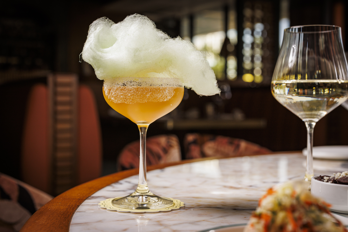 The playful Corona y Caña cocktail arrives topped with a cloud of cotton candy, leaning into Maroma’s tropical, resort-inspired approach to drinks and presentation. | Photo by Samantha Marie Photography