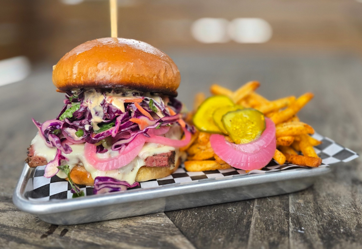 Jimmie’s Jerk BBQ puts a Caribbean spin on barbecue with bold, spice-rubbed sandwiches piled high with slaw, pickled onions, and smoky meat alongside seasoned fries. | Photo by Jimmie's Jerk BBQ