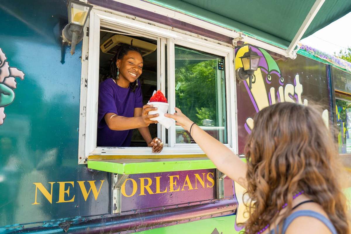 A guest picks up a snoball at the window of the Just Loaf'N New Orleans Poboys & Snoballs truck. | Photo by Just Loaf'N New Orleans Poboys & Snoballs 