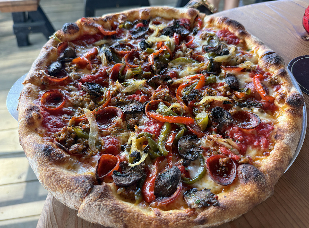 The Davis Street pizza at Kilmac’s layers pepperoni, Italian sausage, roasted mushrooms, caramelized onions, and peppers on a chewy New York-style crust. | Photo by Desiree Gutierrez