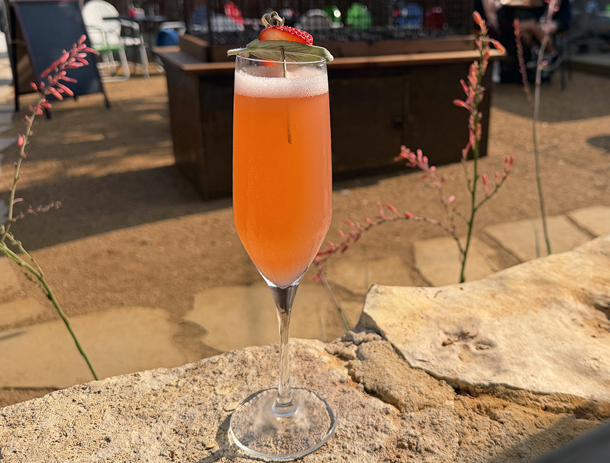 Kilmac’s Dragon’s Breath cocktail blends bright citrus and smoky heat, served in the restaurant’s sprawling Oak Cliff cocktail garden. | Photo by Desiree Gutierrez