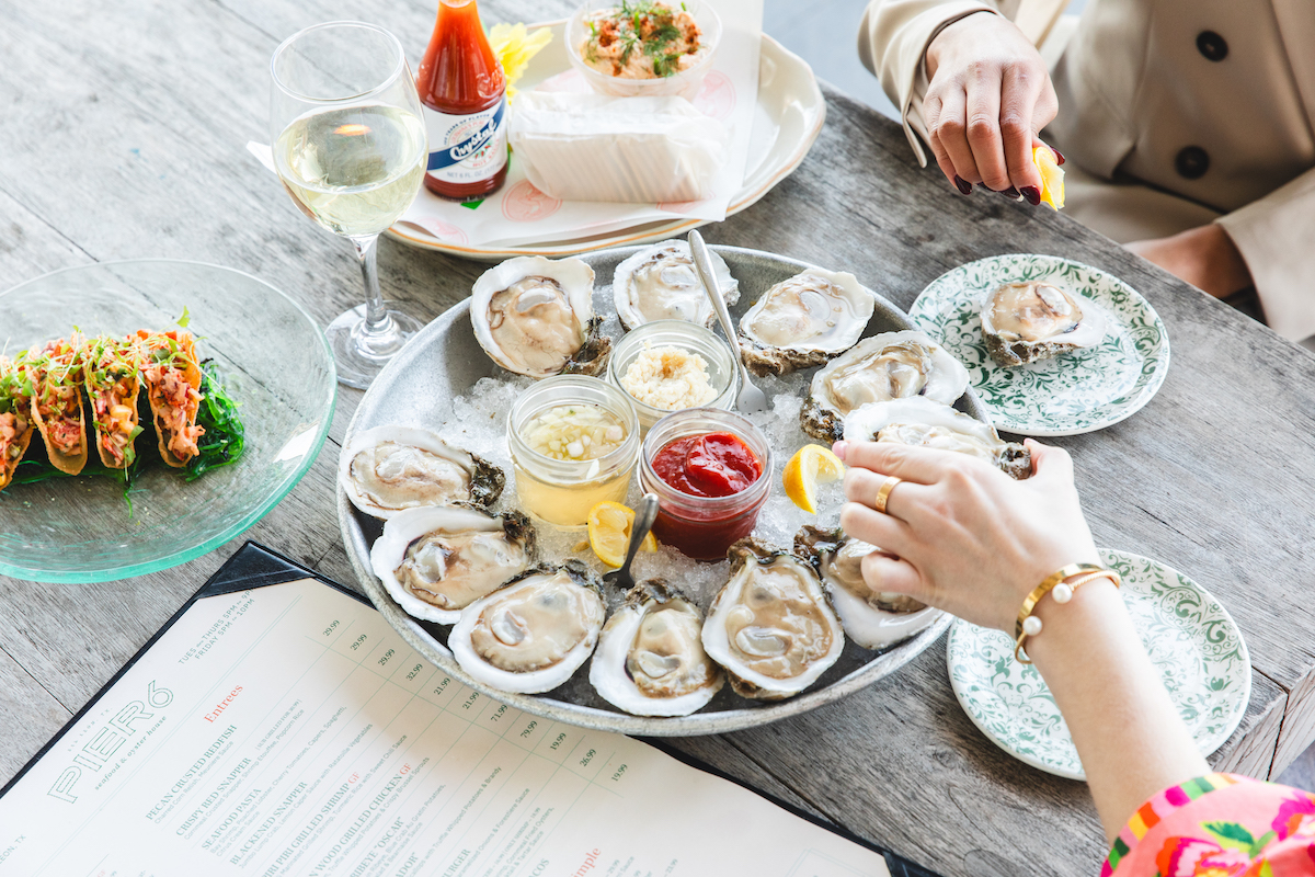 Fresh Gulf oysters take center stage at Pier 6 Seafood & Oyster House, where waterfront views and seafood towers make the drive to San Leon well worth it. | Photo by Becca Wright