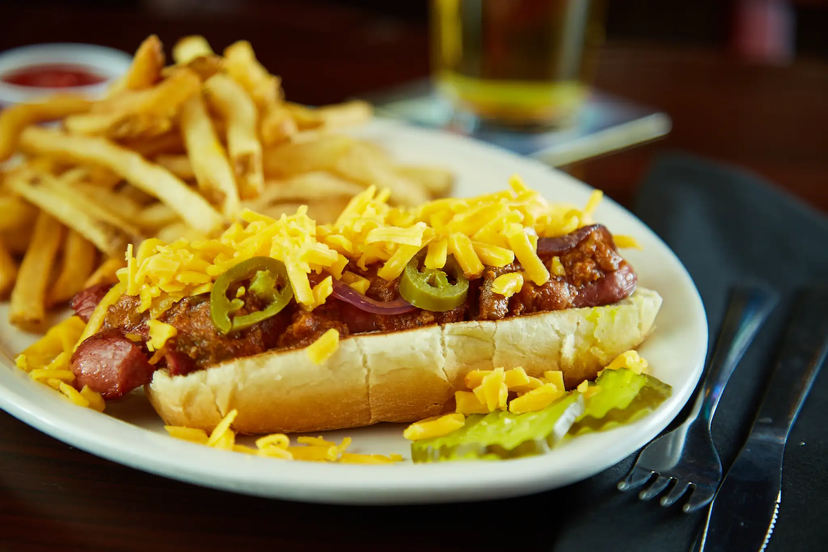 Angry Dog's signature chili cheese dog comes piled high with meaty Texas chili, shredded cheddar, grilled onions, jalapeños, and mustard. | Photo by Angry Dog